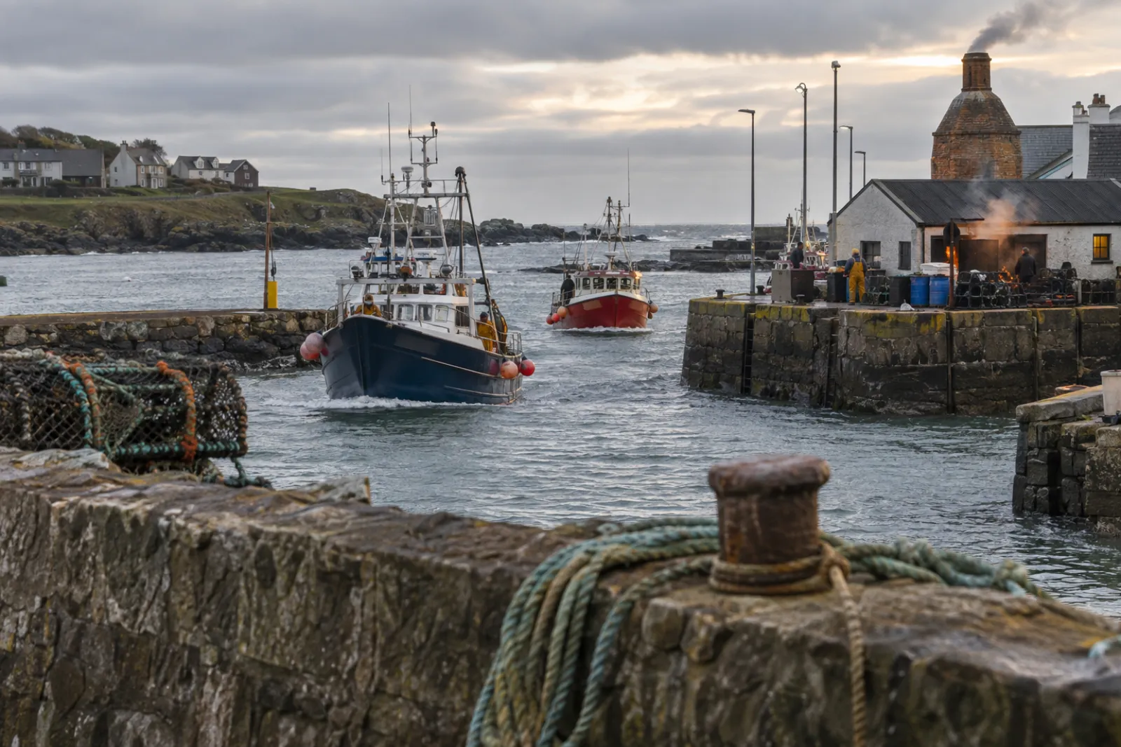 Boats coming into Ardglass harbour, the harbour wall in the foreground